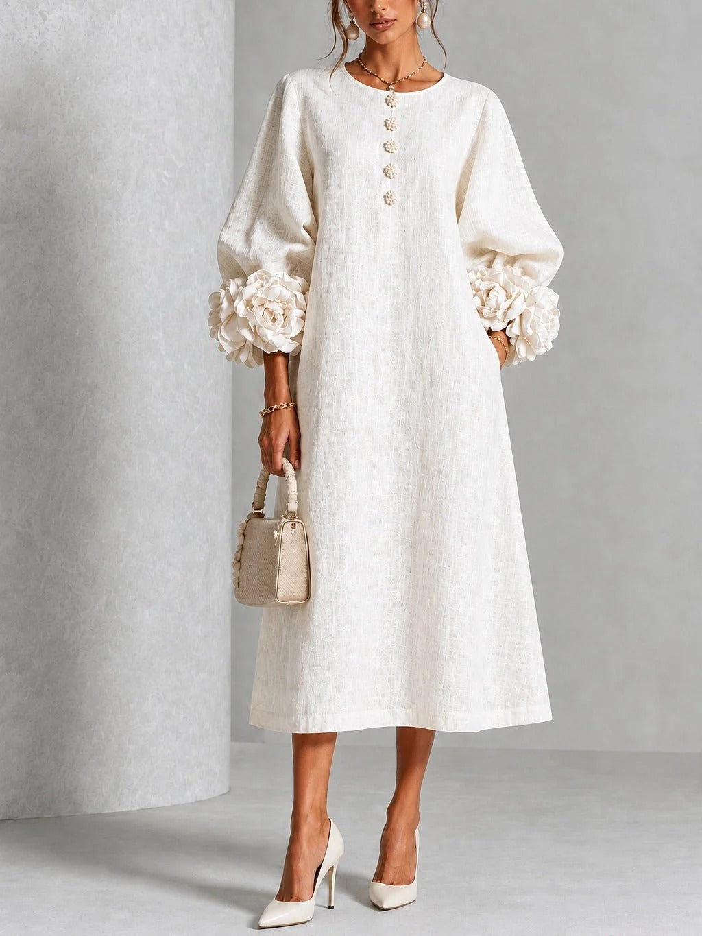 Vestido midi blanco con botones florales y mangas decoradas.