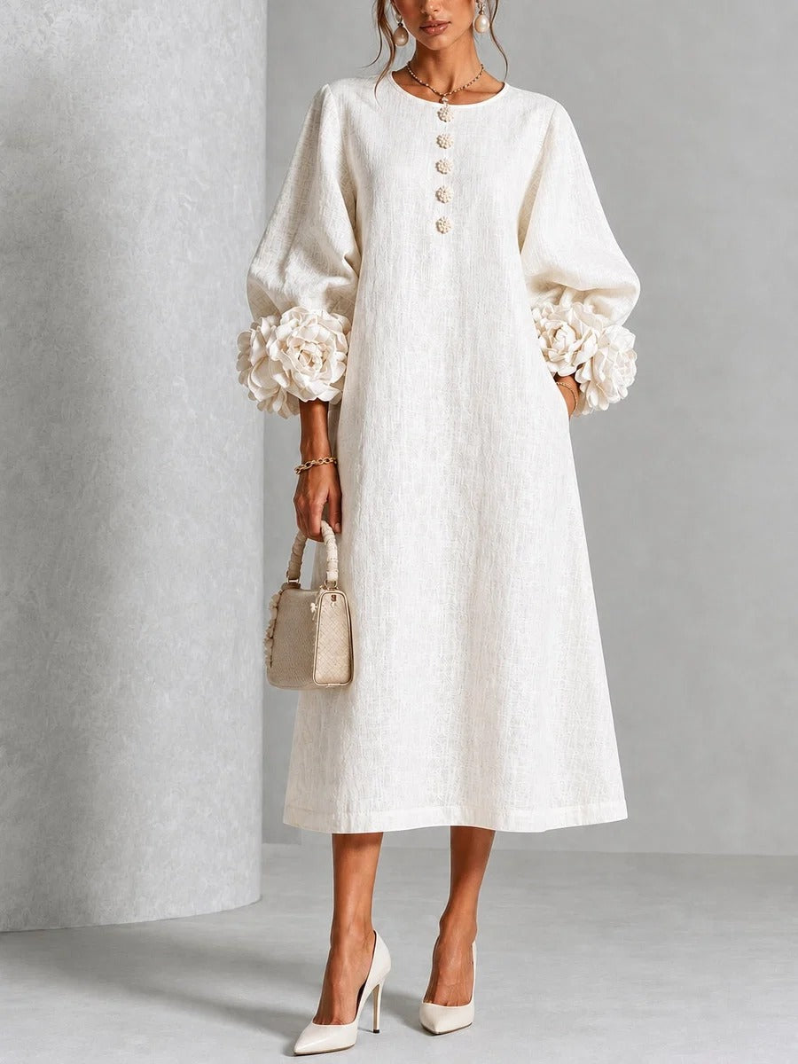 Vestido midi blanco con botones florales y mangas decoradas.