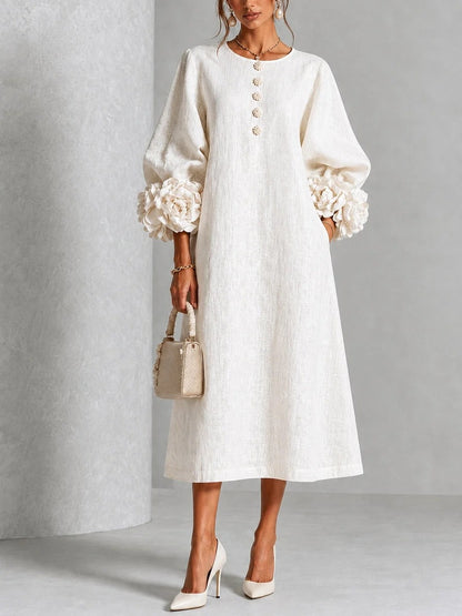 Vestido midi blanco con botones florales y mangas decoradas.