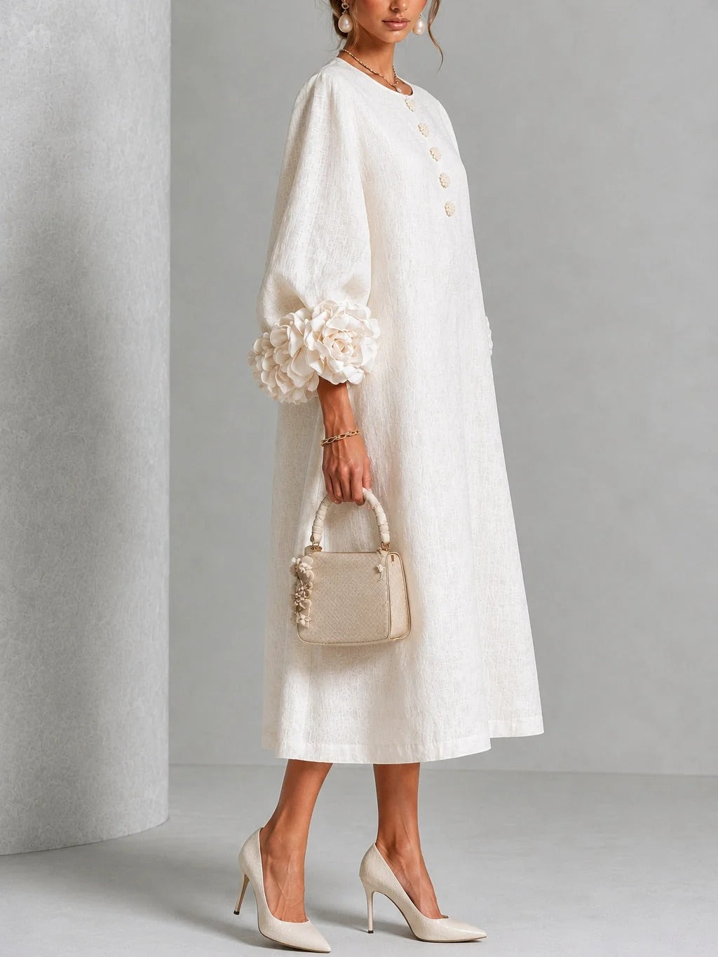 Vestido midi blanco con botones florales y mangas decoradas.