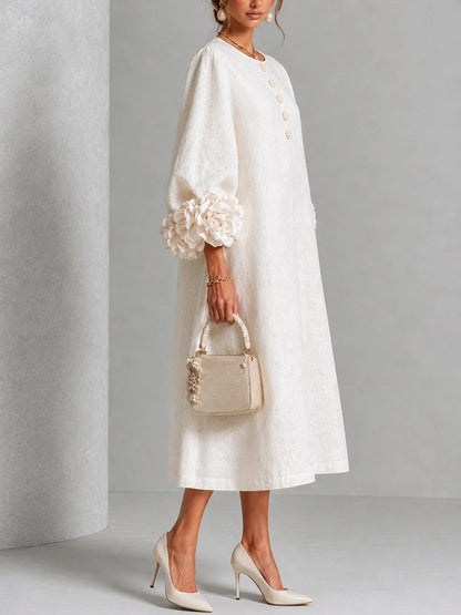 Vestido midi blanco con botones florales y mangas decoradas.