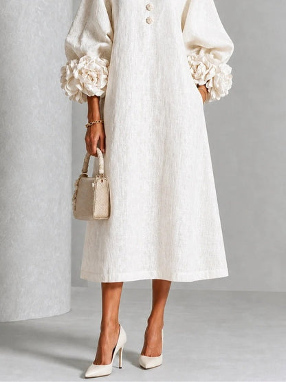 Vestido midi blanco con botones florales y mangas decoradas.