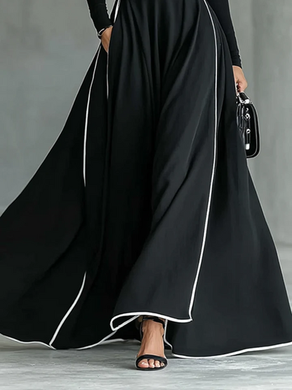 Vestido largo negro para mujer con costuras blancas, cuello alto, mangas largas y cintura ajustada.