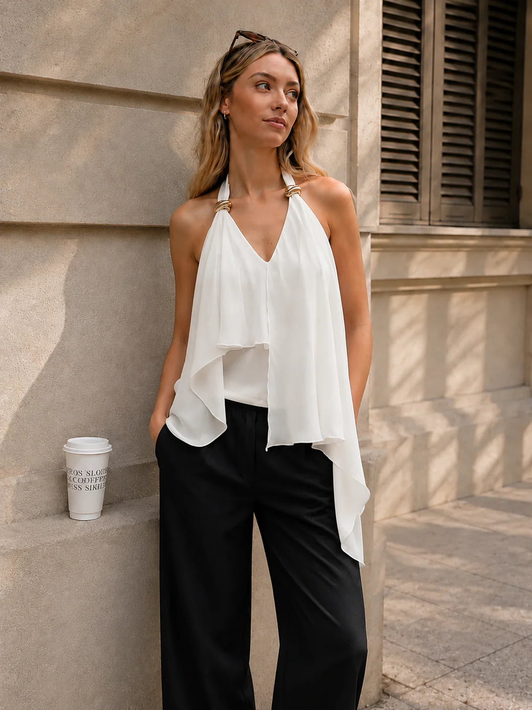 Top asimétrico fluido con detalles metálicos y escote halter.